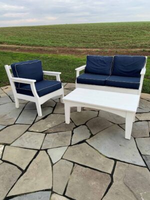 Outdoor couch, chair, and coffee table in white Poly and blue cushions.